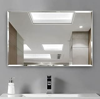 Espelho retangular decorativo para banheiro com moldura prateada refletindo pia e luz do teto
