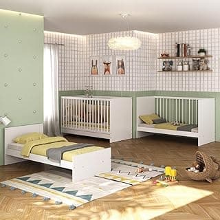 Quarto infantil com berço branco, mini berço branco e cama de solteiro branca, parede verde com padrões de quadrados e prateleira com itens decorativos.