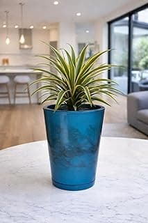 Vaso azul petróleo para plantas em forma de coluna com acabamento marmorizado em um ambiente de interior.