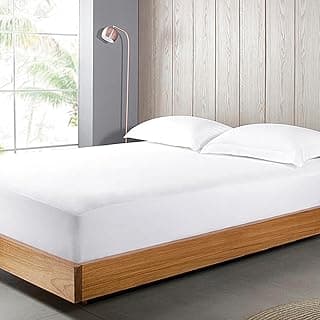 Colchão branco Buddemeyer Queen Maison II com fronha e cama marrom em quarto com painéis de madeira