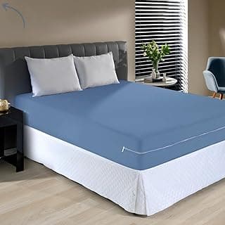 Capa protetora para colchão queen azul e branco em uma cama queen com dois travesseiros