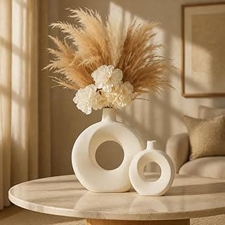 Conjunto de vasos decorativos brancos com flores e pampas grass em uma sala moderna