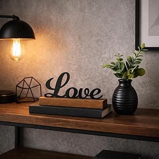 Kit decorativo minimalista com letreiro Love em madeira, vaso preto fosco e folhagem artificial.