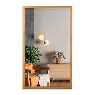 Espelho com moldura decorativa 48x80cm em freijó refletindo sala com cadeira e planta