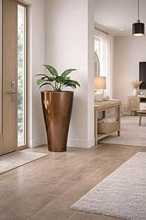 Vaso grande cônico liso marrom para planta com uma planta verde no interior, em um ambiente de sala com piso de madeira e paredes brancas.