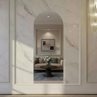 Sala com decoração moderna, parede curva em mármore branco, sofá branco, mesa redonda e arranjo de flores.