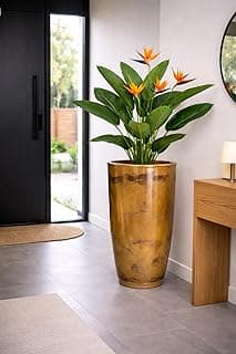 Vaso grande de polietileno marmorizado dourado com planta florida em ambiente interno