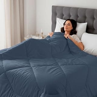 Edredom azul escuro em uma cama com uma mulher deitada confortavelmente