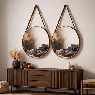 Kit com 2 espelhos decorativos Adnet 30cm com alça em couro caramelo pendurados na parede