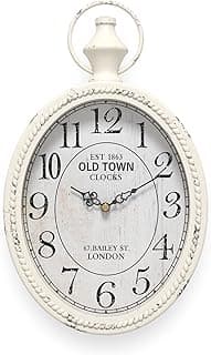 Relógio de parede oval branco estilo vintage com design retrô, números pretos e texto decorativo.