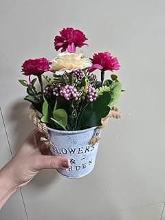 Arranjo de flores artificiais em vaso de metal vintage com alças de corda de juta, inscrição 'FLOWERS & GARDEN', fundo bege