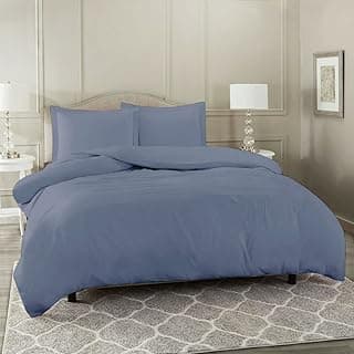 Conjunto de edredom azul marinho queen size em uma cama com um tapete cinza e branco.