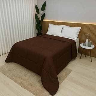 Edredom Roma de cor tabaco, tamanho solteiro, sobre cama com travesseiros brancos.