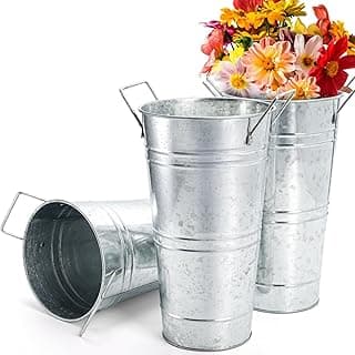 Três vasos de metal galvanizado com alças, um contendo flores