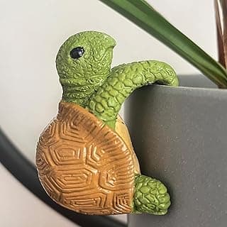 Estatueta de mini tartaruga verde e marrom segurando um vaso de plantas