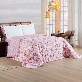 Edredom king rosa floral com fundo claro, cama com travesseiros brancos, parede branca e persianas.