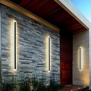 Luminárias de parede longas LED modernas para uso externo iluminando uma parede de pedra cinza