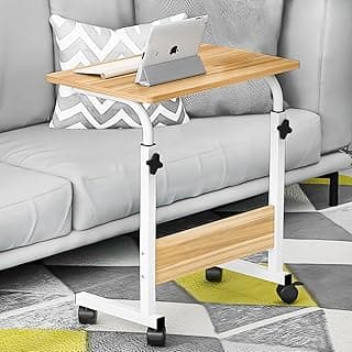 Mesa dobrável ajustável em madeira e metal branco, com rodas, sobre um sofá cinza.