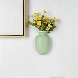 Vaso decorativo verde claro com flores amarelas na parede