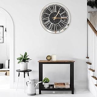 Relógio de parede grande com design de diamantes, espelho e números romanos, montado na parede em um ambiente minimalista.