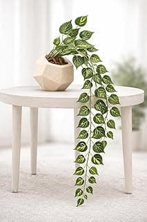 Planta artificial pendente com vaso geométrico moderno, folhas verdes, mesa branca