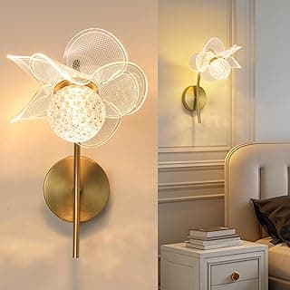Arandela dourada moderna com design floral, iluminação suave, parede branca, vista frontal e lateral.