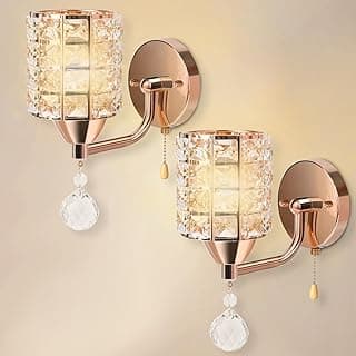 Duas luminárias de parede douradas com cúpulas de cristal e pendentes de cristal.