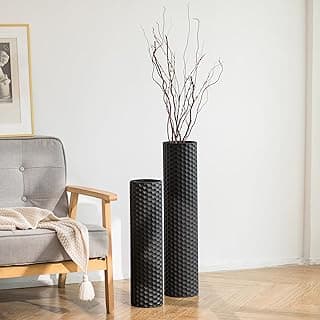 Dois vasos decorativos cilíndricos de metal preto com textura de favo de mel em um ambiente minimalista