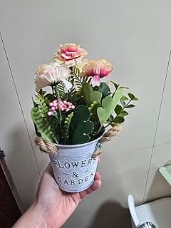 Arranjo de flores artificiais rosa e brancas em vaso de metal vintage com alças de corda de juta