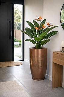 Vaso grande de polietileno marrom com acabamento marmorizado, com planta de folhas verdes e flores amarelas.