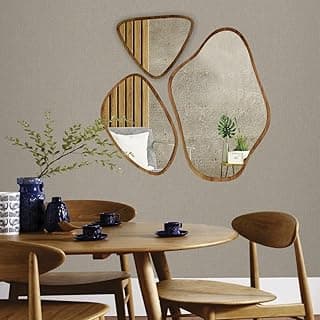 Conjunto de 3 espelhos orgânicos decorativos em madeira, pendurados na parede, com reflexos de plantas e almofada.