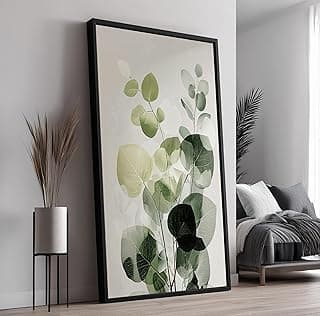 Quadro decorativo com moldura preta, folhas verdes e brancas, decoração de interiores.