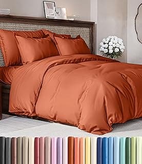 Capa de edredom terracota king-size em uma cama arrumada com almofadas e flores brancas ao lado
