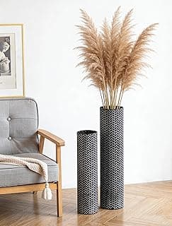 Dois vasos cilíndricos pretos com textura tecida e padrão geométrico em zigue-zague, contendo uma planta alta com folhas finas.