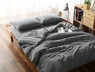 Edredom cinza em cama com travesseiros e decoração minimalista