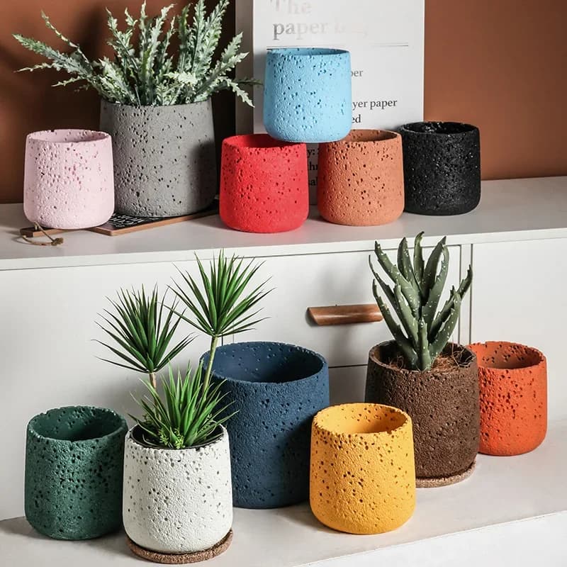 Vasos decorativos de cimento em cores vibrantes para plantas em uma prateleira