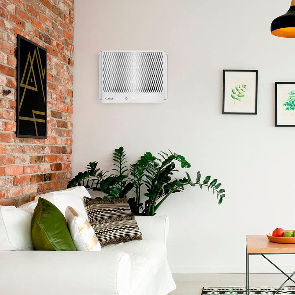 Ambiente com ar condicionado janela Consul 7500 BTUs instalado em sala moderna com sofá branco e almofadas verdes