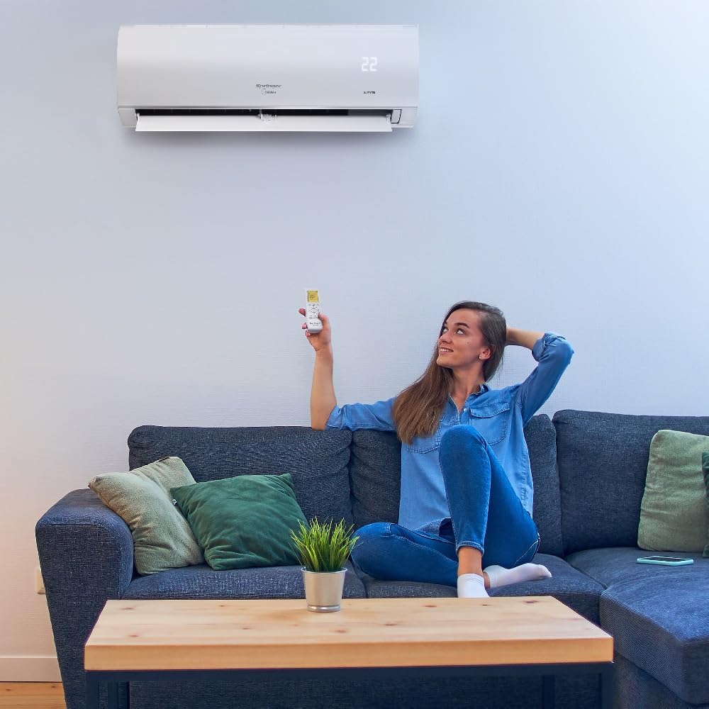Mulher em sofá usando controle remoto para ar condicionado split Springer Midea AirVolution branco instalado na parede
