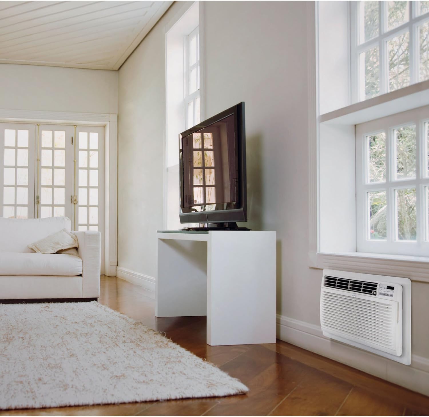 Ar condicionado de janela LG instalado em sala moderna, próximo a sofá branco e TV.