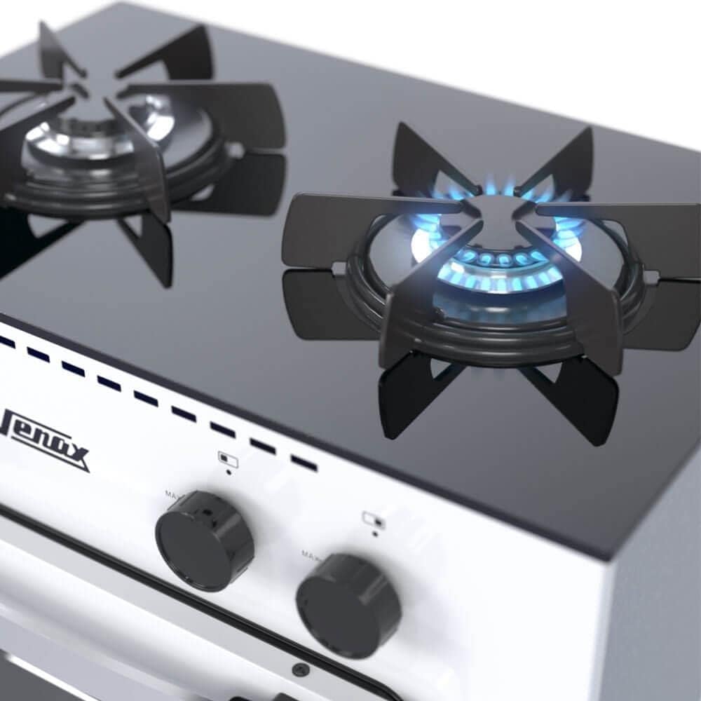 Bocas do fogão Venax Mini Cook 2Q com chamas acesas, tampo preto e grades pretas.