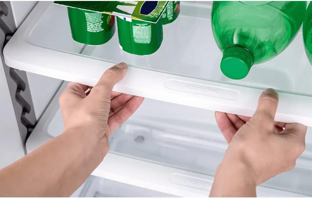 Mãos ajustando prateleira dentro do refrigerador Consul branco