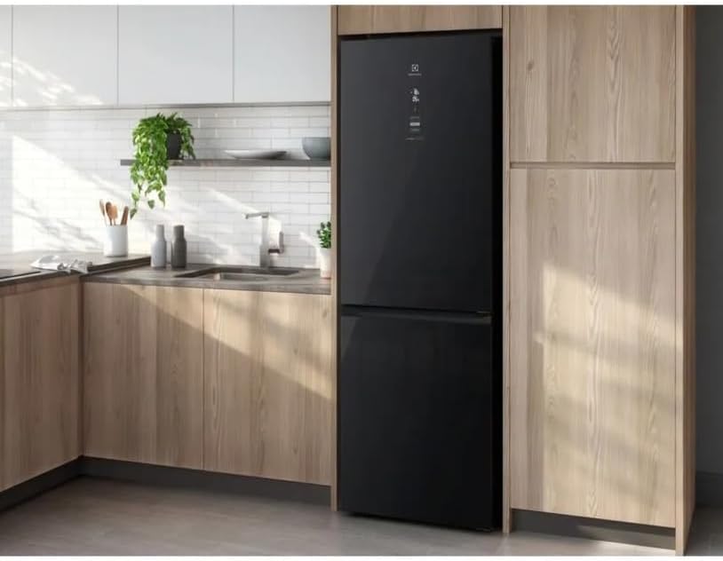 Geladeira Electrolux Inverter preta embutida em cozinha moderna com armários de madeira clara.