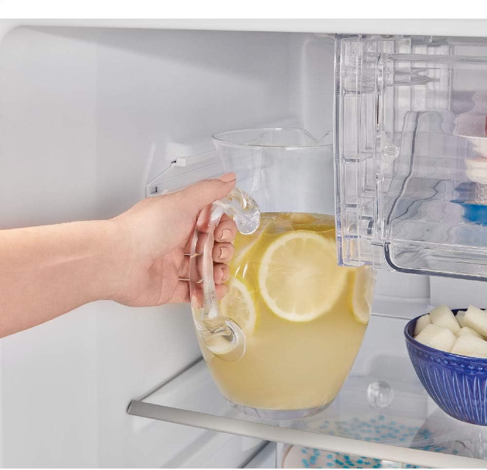 Mão segurando jarra de limonada na geladeira Panasonic Frost Free com prateleiras de vidro