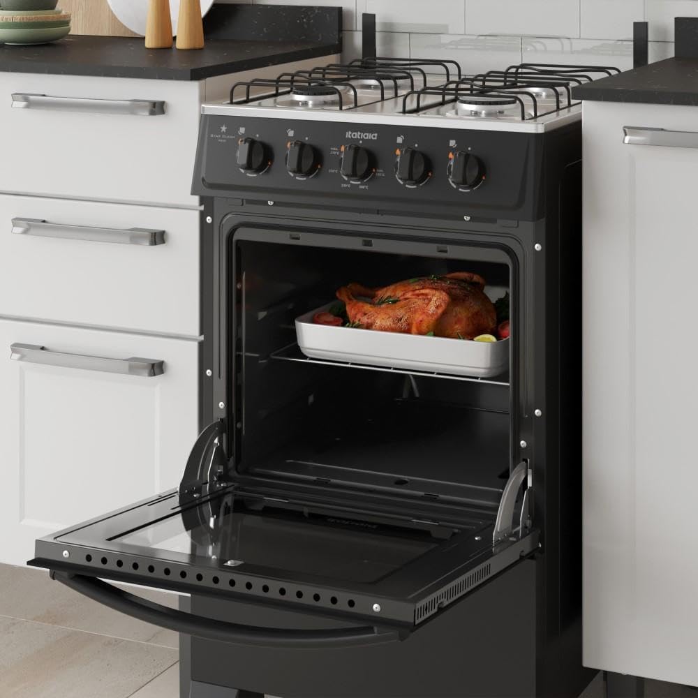 Fogão Itatiaia 4 bocas preto com forno aberto e alimento assado dentro, instalado em cozinha