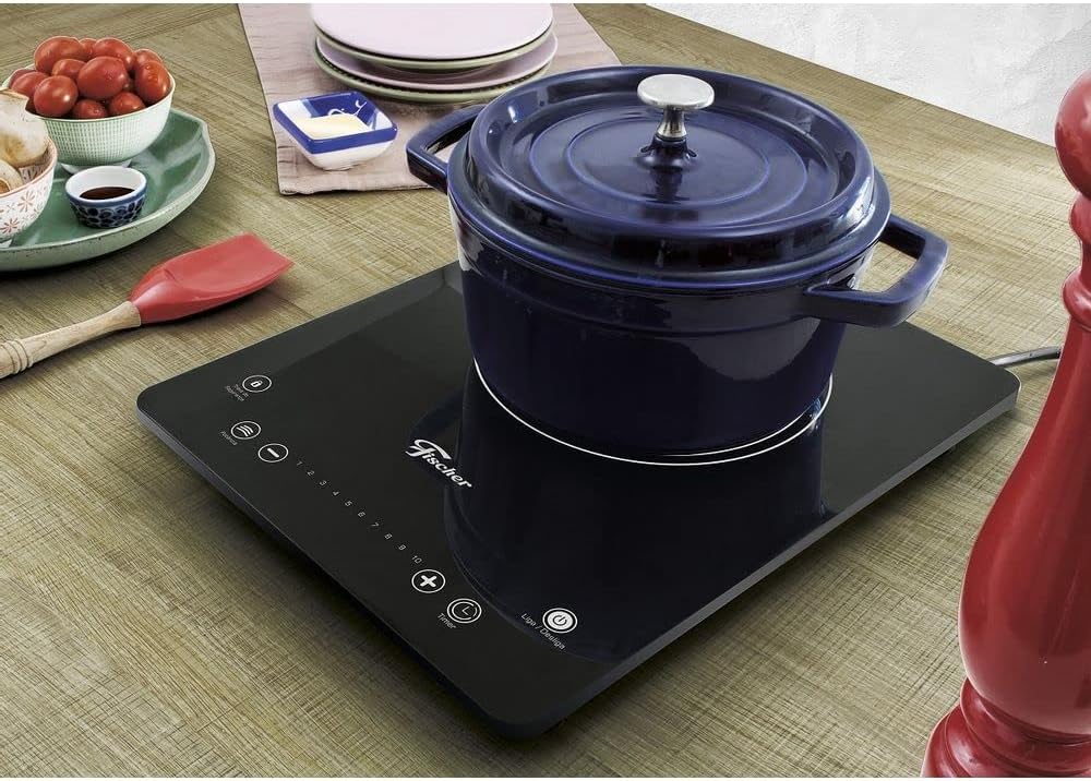 Cooktop indução Fischer vitrocerâmico preto com panela azul na mesa de madeira