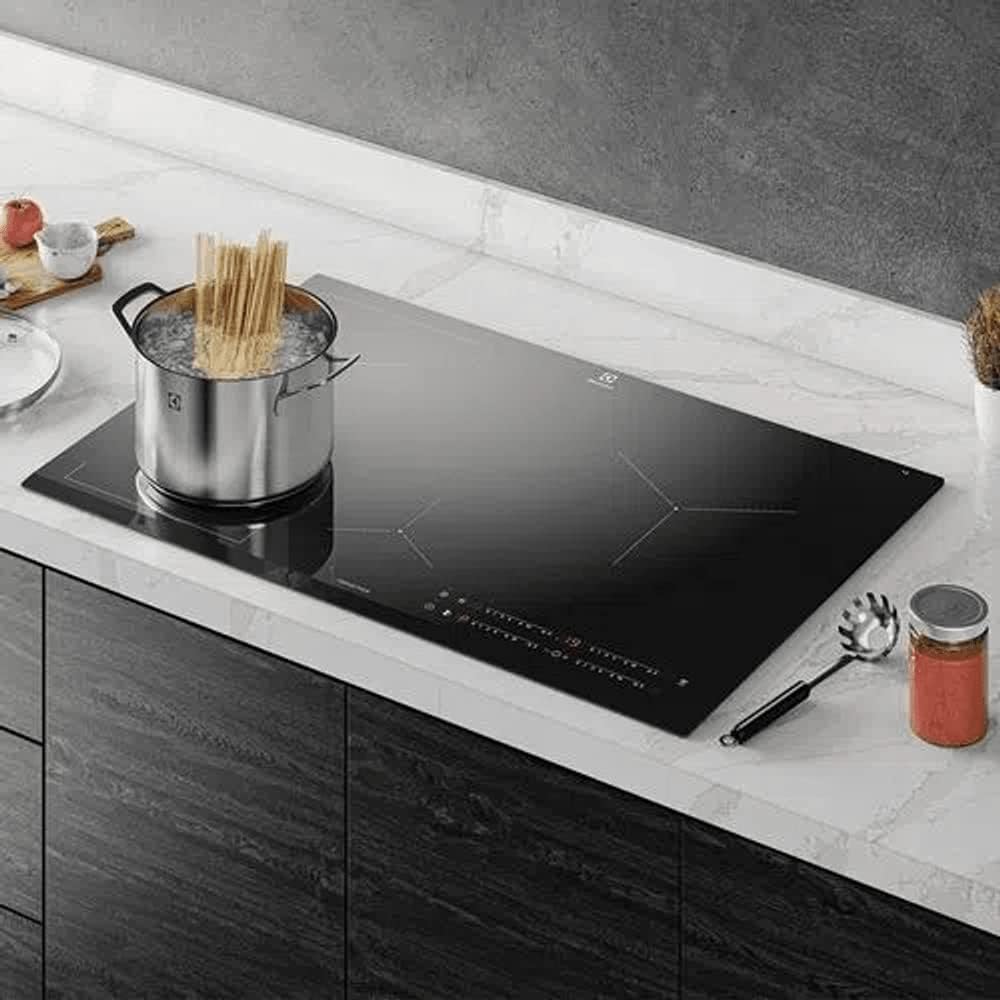 Cooktop de indução Electrolux em bancada cozinha moderna com utensílios