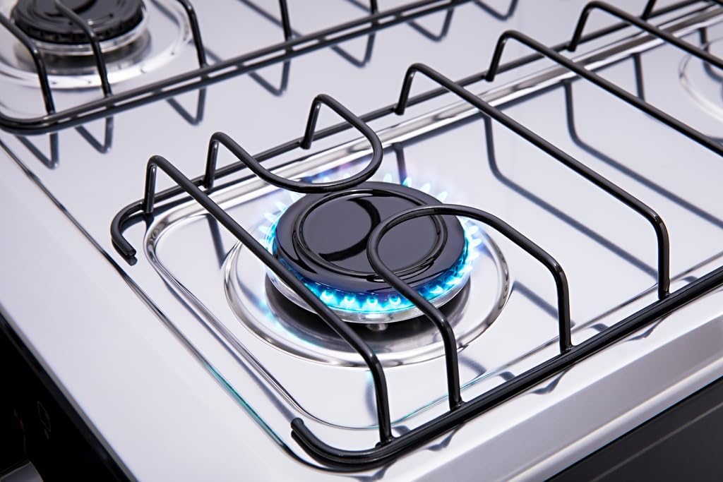 Queimador aceso com chama azul do fogão Atlas 4 bocas Coliseum Plus, grade preta e superfície inox.